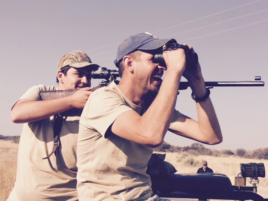 Two generations of hunters glassing the veld together